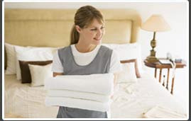 housekeeper holding clean towels in a bedroom